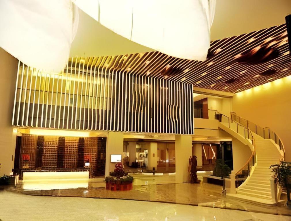 een lobby met een trap in een gebouw bij Ramada Plaza by Wyndham Shaowu in Liaojiapai