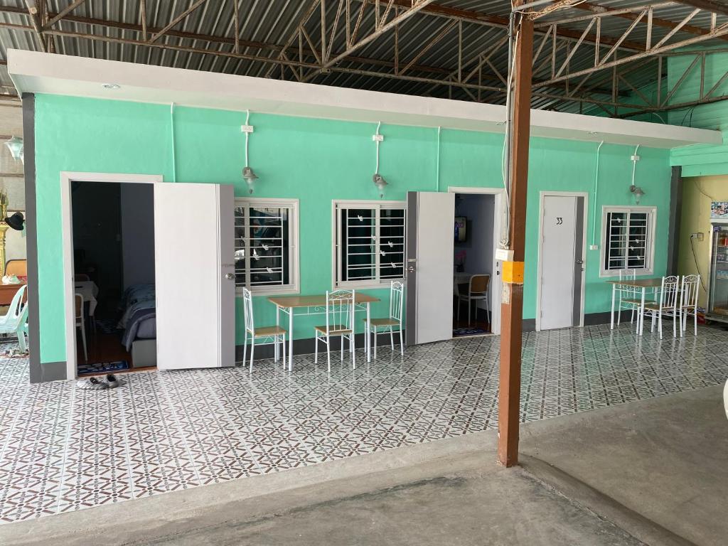 a room with green walls and a table and chairs at Ban Pak Khun Taa in Khon Kaen