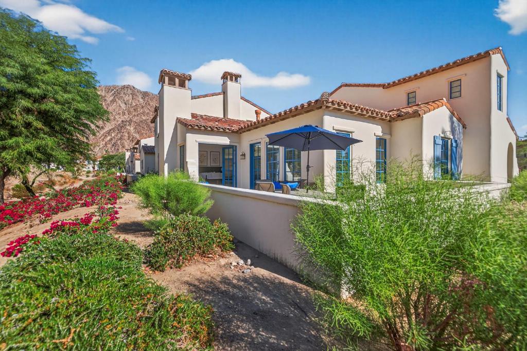 a house with an umbrella in front of it at LV305 Legacy Villas Townhome w Expansive Patio in La Quinta