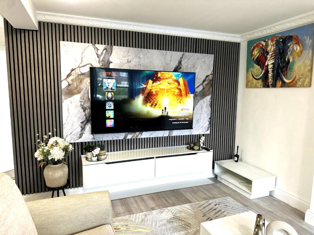 un salon avec une télévision à écran plat sur un mur dans l'établissement Ama comfort Stay, à Hythe