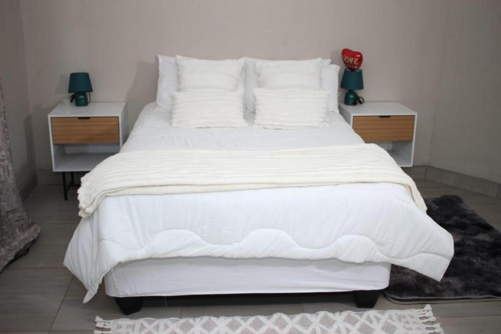 a large white bed with white sheets and pillows at LESEGO LA RONA Villa in Manamakgoteng