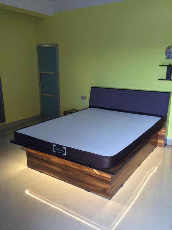 una cama grande en una habitación con colchónvisorvisorvisor en Niroda Guest House, Jorhat, en Jorhat