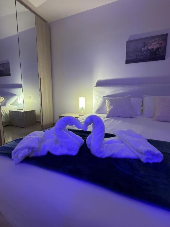 ein Schlafzimmer mit einem Bett, auf dem Schwanenhandtücher liegen in der Unterkunft FaraHome in Acitrezza