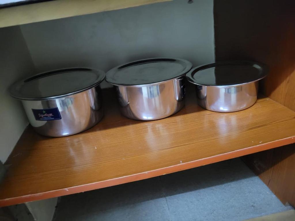 four metal pots on a wooden shelf in a kitchen at Diani Airport View Apartments in Diani Beach