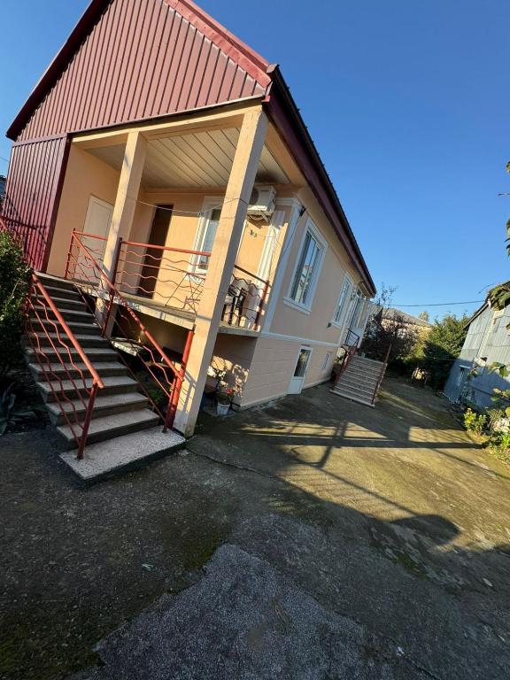 a house with a staircase leading up to a porch at Cozy-home in Kobuleti