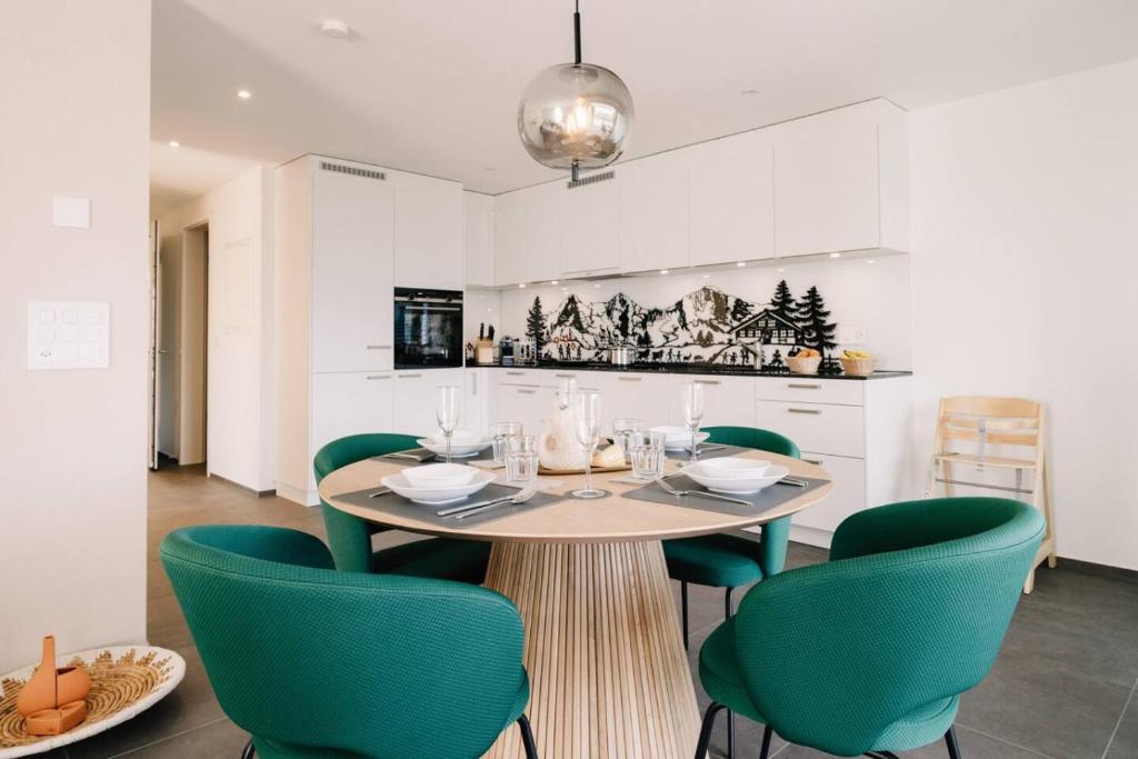 a dining room with a table and green chairs at Apartment Mönch in See- und Bergnähe, modern, mit Balkon, 4 Gäste in Einigen