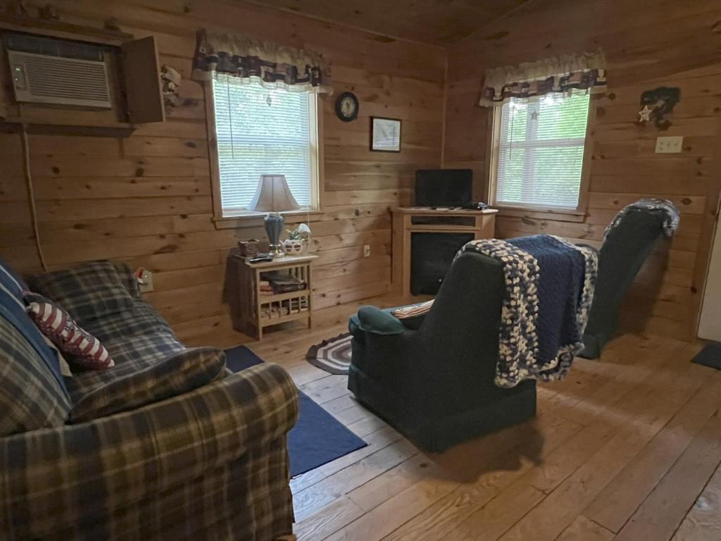 ein Wohnzimmer mit zwei Sofas und einem Fernseher in der Unterkunft Bitter Goose Cabin in Barnettstown