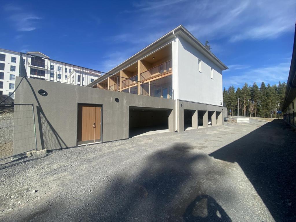 un grand bâtiment blanc avec une ombre sur le sol dans l'établissement Convenient Apartment for 4 with Sauna, à Seinäjoki