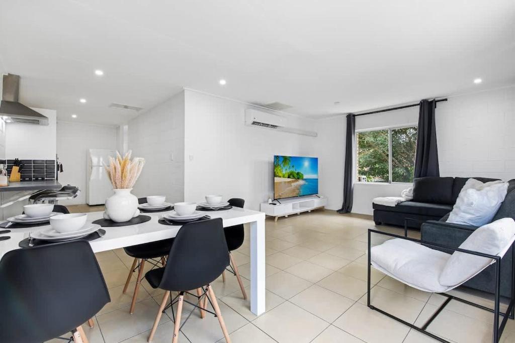 a kitchen and living room with a table and chairs at The Coastal Escape - Games & Vibes in Gold Coast