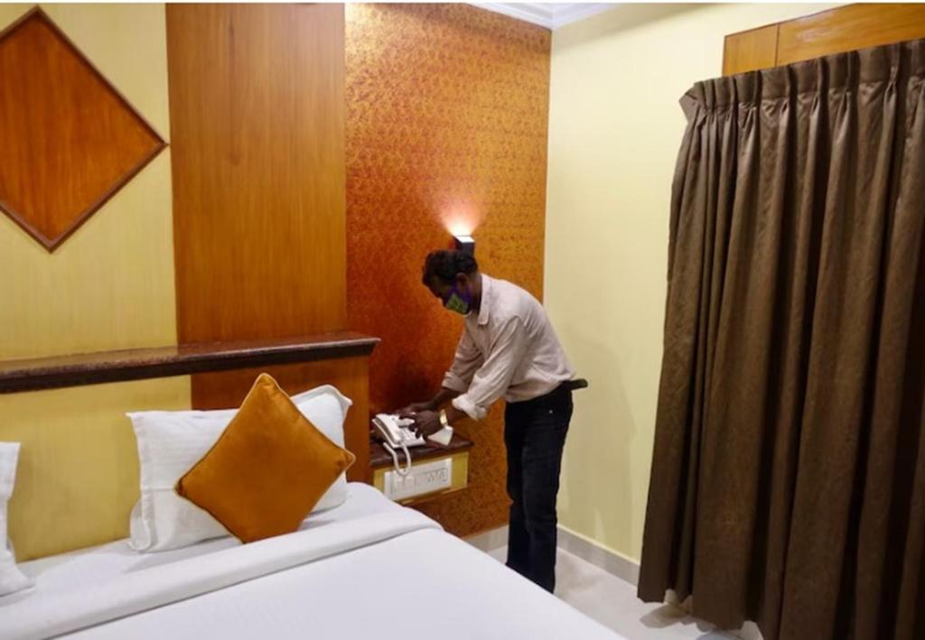 a man is standing in a hotel room at I Residency in Puducherry
