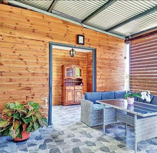 patio con divano blu e tavolo di La kazolie a Sainte-Rose