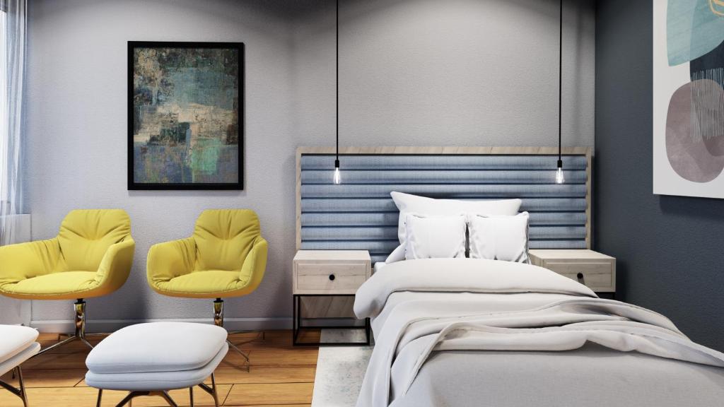 een slaapkamer met een bed en 2 gele stoelen bij Papagei Cosy Home in Staßfurt