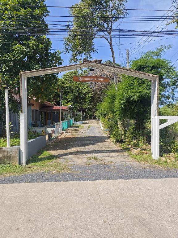 an archway over a road with a street sign at Blooming Village by Aforetime in Taling Ngam Beach
