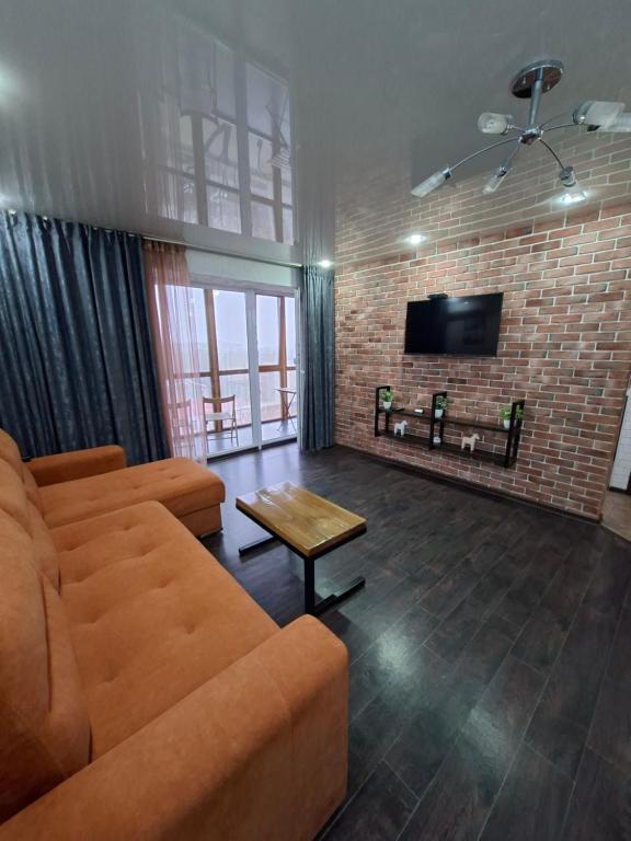 ein Wohnzimmer mit Sofa und Fernseher in der Unterkunft Квартира с видом на парк,в минуте ходьбы от Акимата,Налоговой, Прокуратуры,Рахмета,Dostyk Mall,ЦОНа in Petropawlowsk