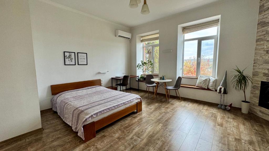a bedroom with a bed and a table with chairs at Апартаменти біля Фортеці in Kamianets-Podilskyi