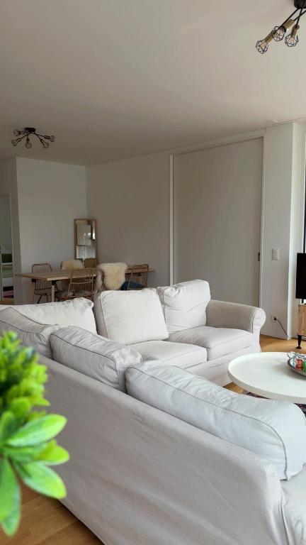 a living room with a white couch and a table at Modern 3-room apartment in Kloten
