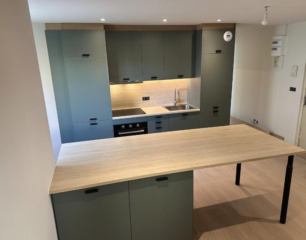 a large kitchen with a wooden counter top at Charmant appartement aux portes de Strasbourg in Oberhausbergen