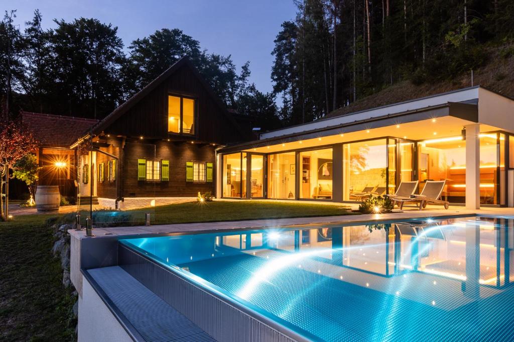 a swimming pool in front of a house at night at eichberg living in Leutschach