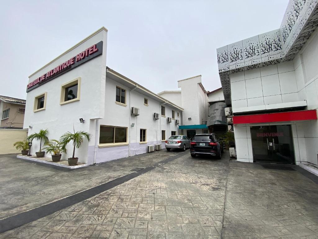 a parking lot in front of a white building at Chateux de atlantique Hotel in Lagos