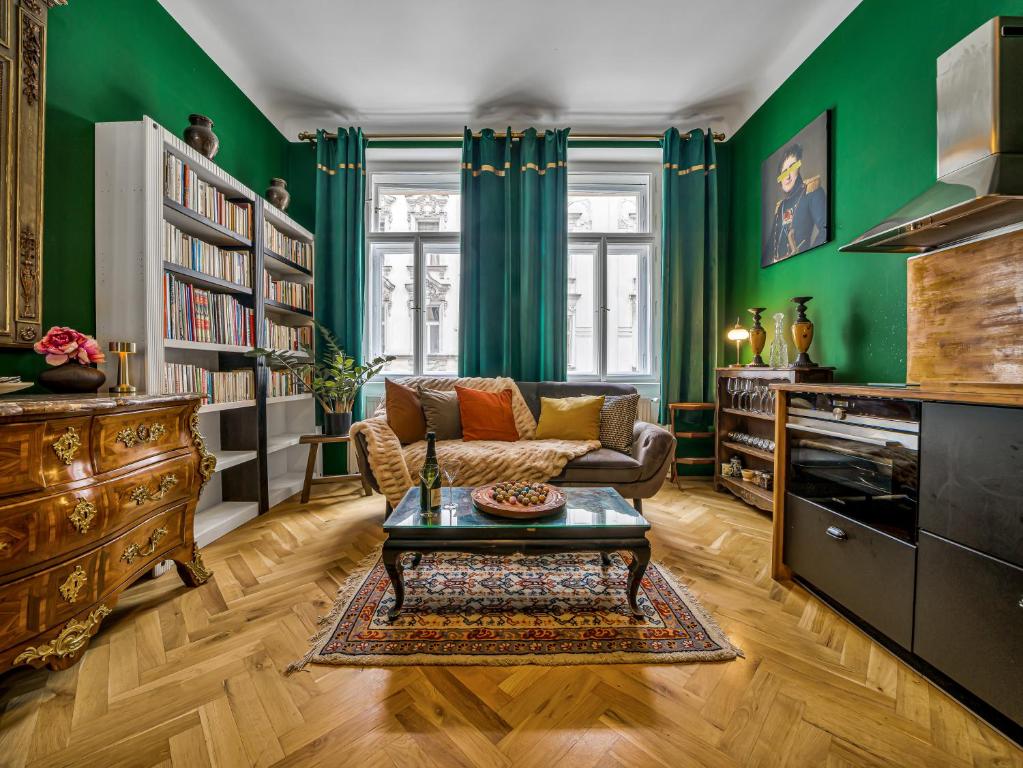 a living room with green walls and a couch and a table at Timeless Prague Apartment by House of Huxe in Golčŭv Jeníkov