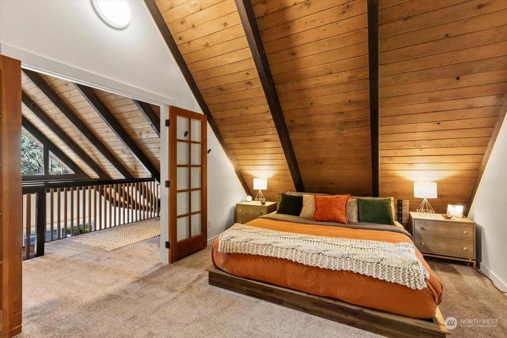 een slaapkamer met een bed en een houten plafond bij Luxury A-Frame with Hot Tub, Fireplace & Firepit in Skykomish