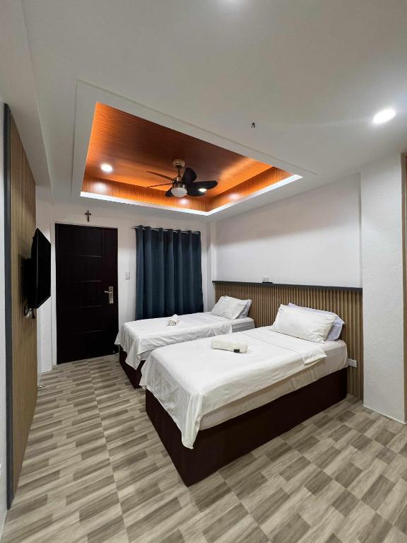 a bedroom with two beds and a television in it at Esprutingkle Business Hotel Kidapawan in Kidapawan