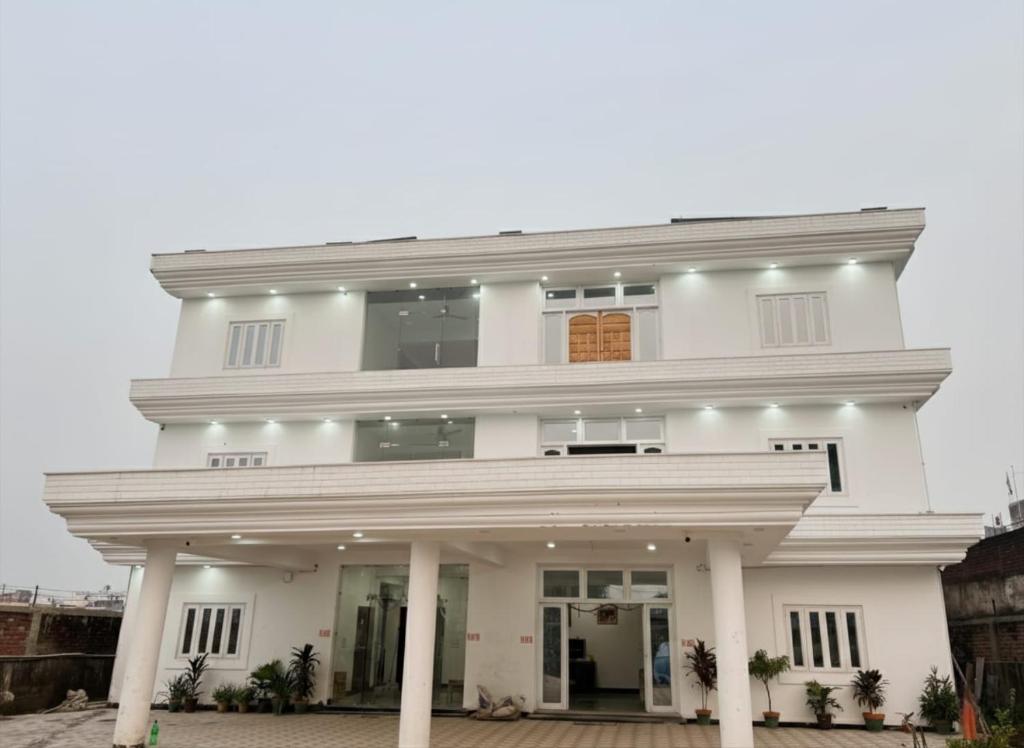 a white house with a large front porch at Regency Villa, 500 meters from Mahabodhi Temple in Bodh Gaya