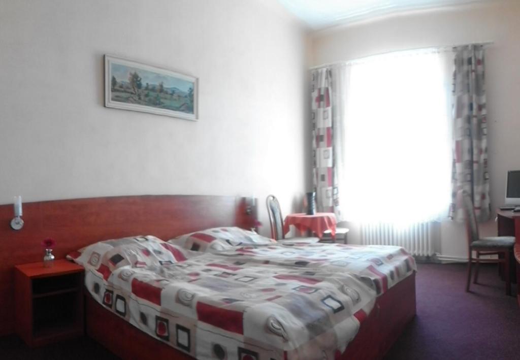 Schlafzimmer mit einem Bett mit einer roten und weißen Decke in der Unterkunft U Jindřicha in Milevsko