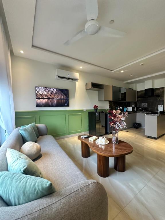 拉合尔Zameen aurum Luxury Apartment Gulberg 3 Mirhaa homes-3的客厅里有一张沙发和一张桌子。