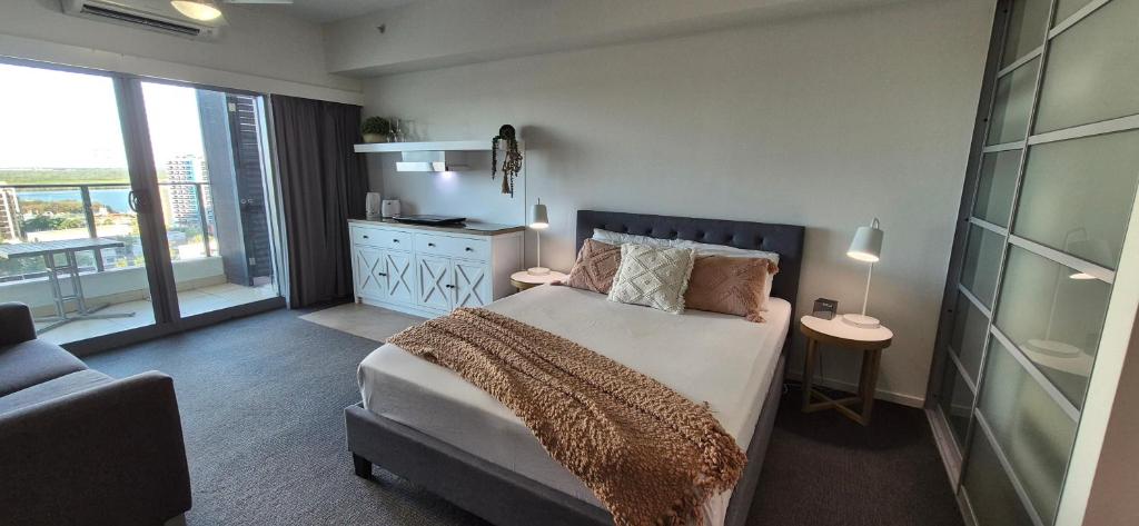 a bedroom with a large bed and a kitchen at ツ Home Away From Home ツ in Darwin