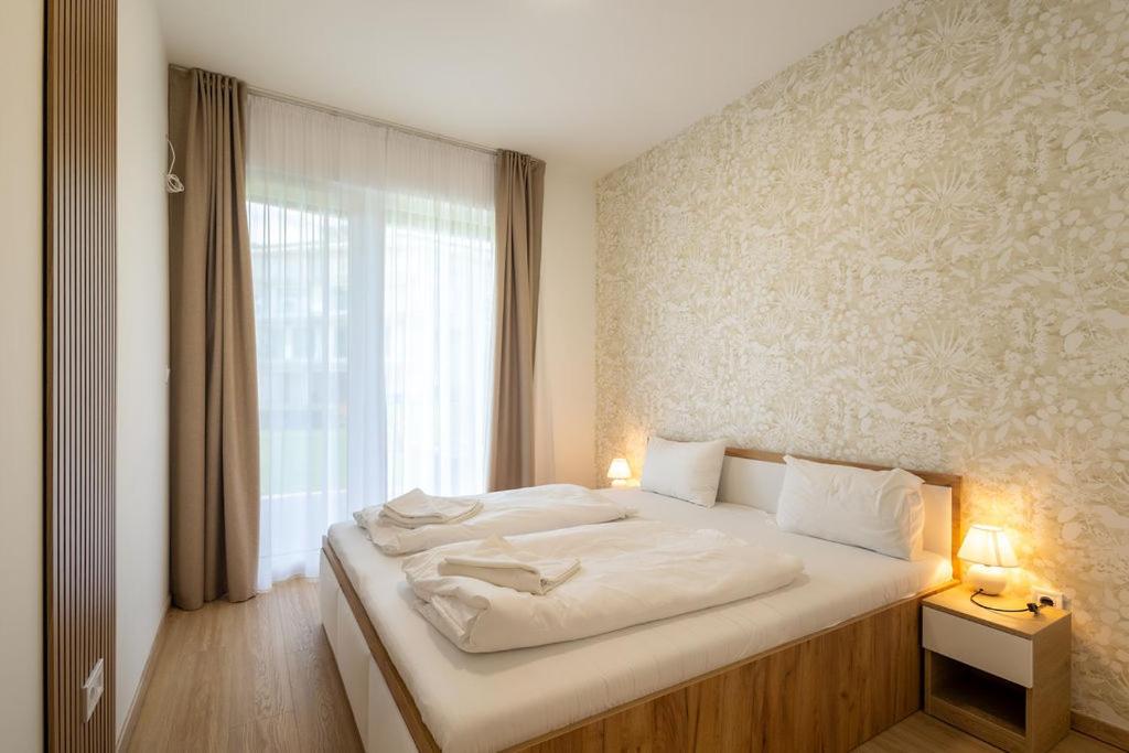 バラトンセメッシュにあるSzemesBay Apartmentの窓のある大きな白いベッドのある寝室