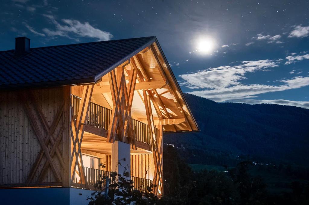 a house at night with the moon in the sky at Steindlgut - Weinberg Chalets in Brixen