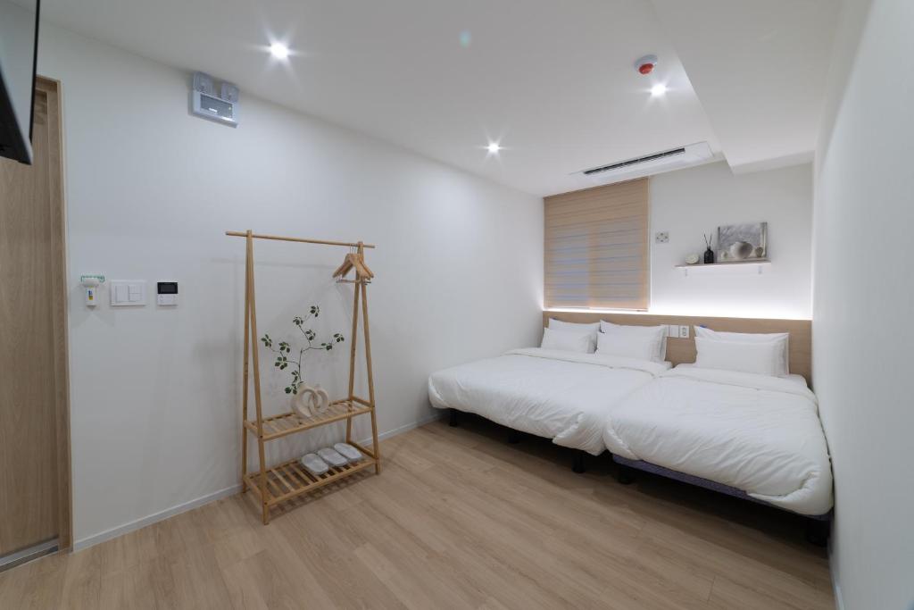 ソウルにあるHi Seoul Hostel Centralの白い枕が付いた大きな白いベッドのある寝室