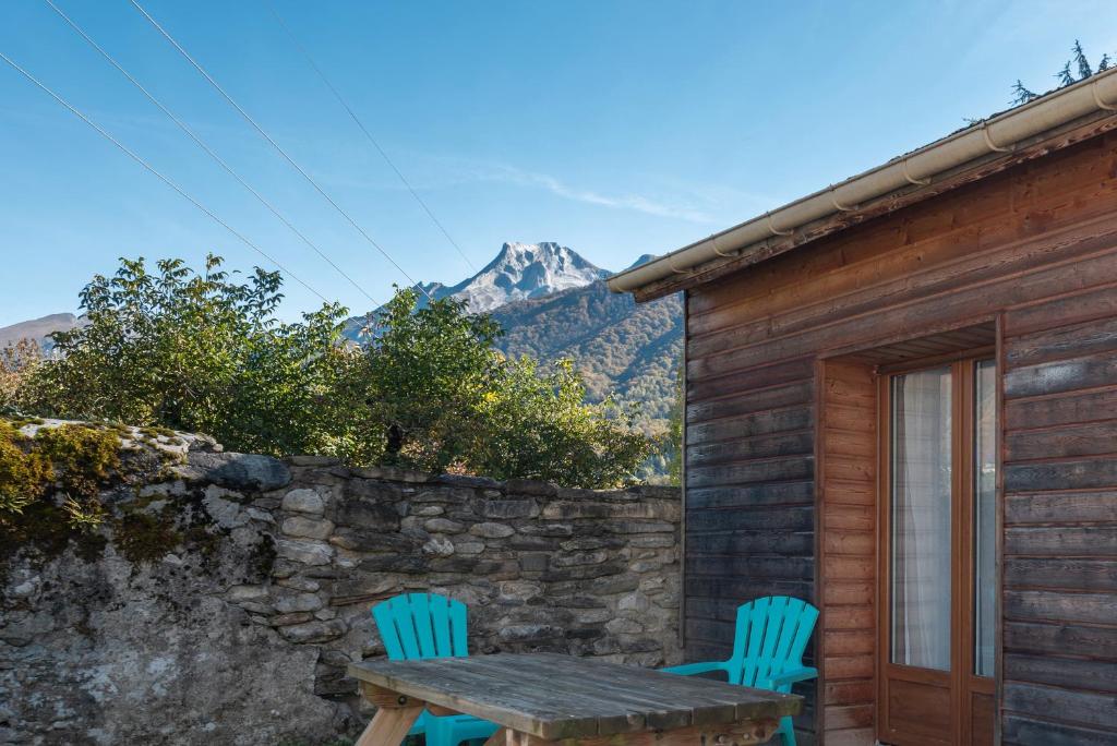 une table et deux chaises assises à l'extérieur d'une cabine dans l'établissement Chalets De L’arriutort 2 - Laruns, à Laruns