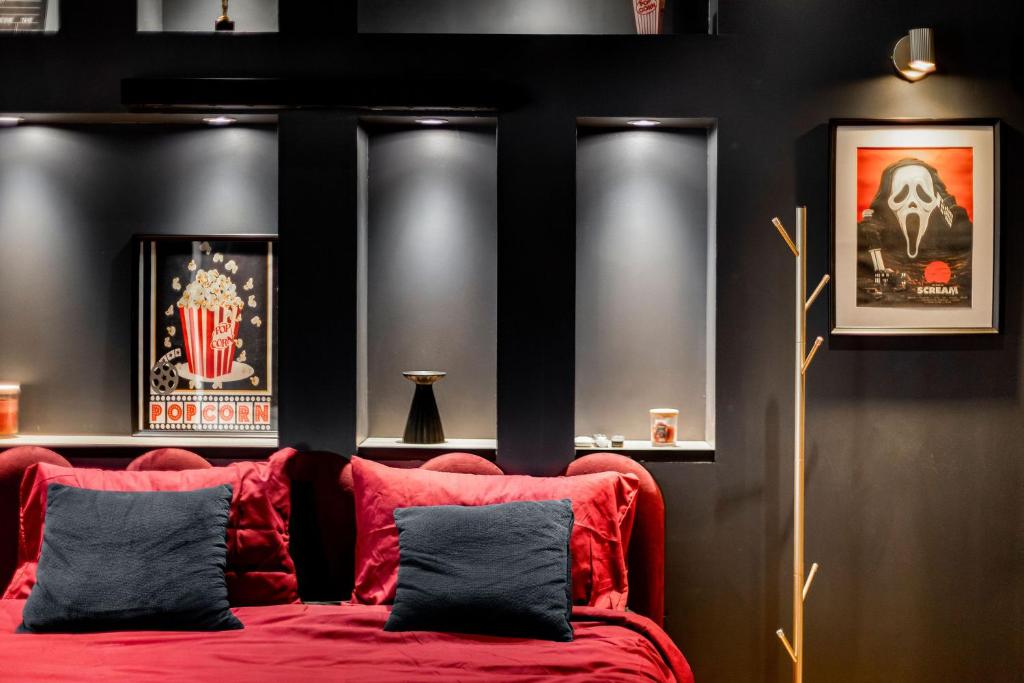 une chambre avec un lit rouge avec deux oreillers dans l'établissement La cinemaRoom d'Auterive - Son Immersif Dolby et Atmos - Netflix, à Auterive