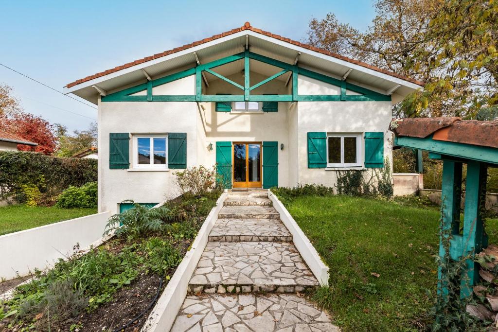 a house with a blue door and a walkway at Chambres d'hotes du Prieur in Léognan