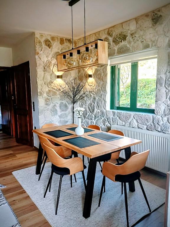 a dining room with a wooden table and chairs at G&J Traditional House in Elati