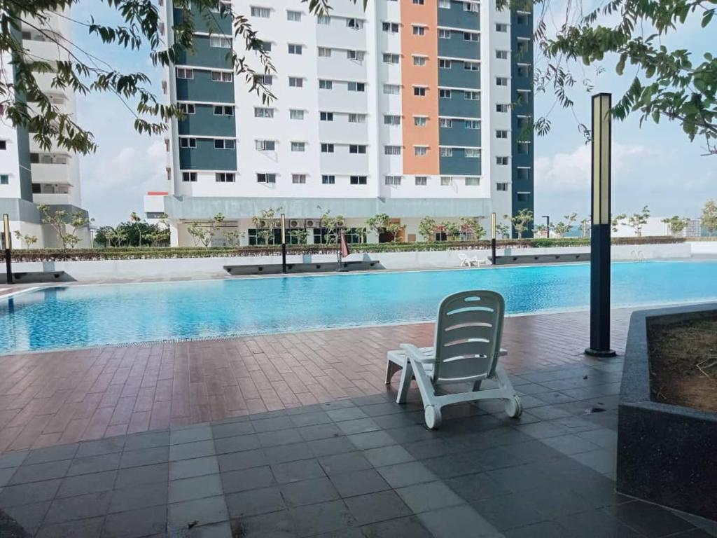 a lounge chair sitting next to a swimming pool at D2303 Camellia Stay, Alanis Near KUL Airport in Sepang