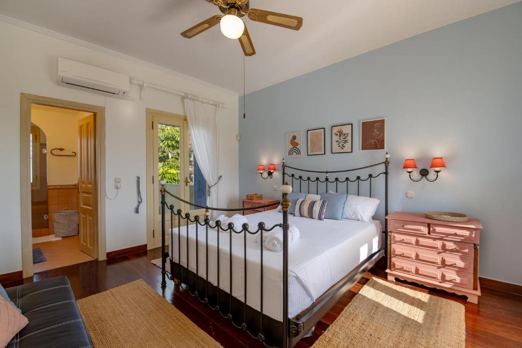 a bedroom with a bed and a ceiling fan at Villa Elmar in Aegina Town
