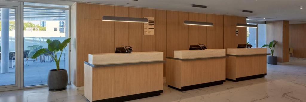 a lobby with a row of desks with a potted plant at City Express by Marriott Santa Ana/Orange County Airport in Santa Ana