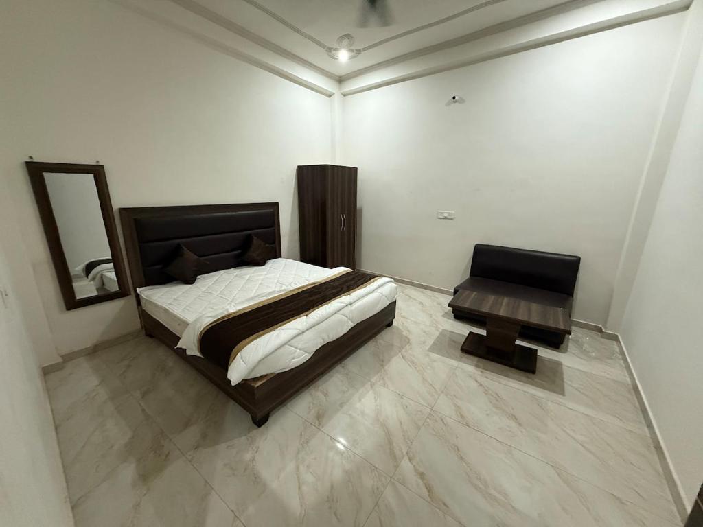 ein Schlafzimmer mit einem Bett und einem Tisch darin in der Unterkunft Grand Vista Kashi 2BHK Home in Varanasi