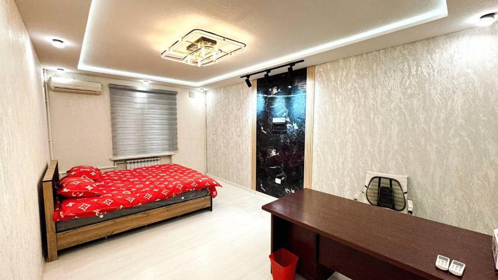 a bedroom with a red bed and a window at Apartments and rooms in Tashkent in Tashkent