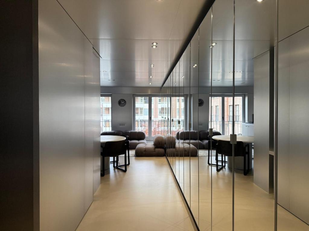 a lobby with chairs and tables in a building at Modern Chromo Design Apartment Center Kortrijk in Kortrijk