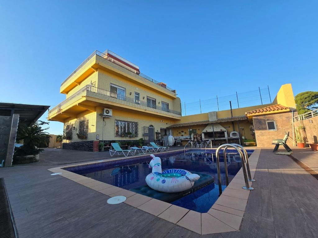 a pool in front of a building with a swimming pool at Piscina climatizada jacuzzi sauna y gym privados para 15 con metro in Picassent