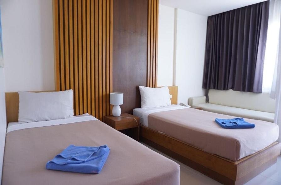 2 Betten in einem Hotelzimmer mit blauen Handtüchern darauf in der Unterkunft Baan KetKaew GuestHouse 1 in Patong Beach