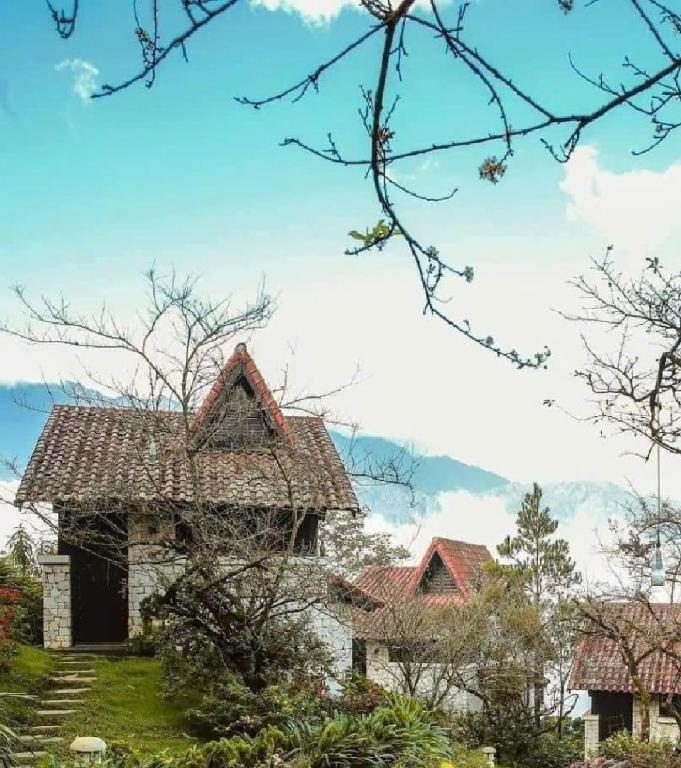 an old house on a hill with mountains in the background at Heaven House Sapa in Sapa
