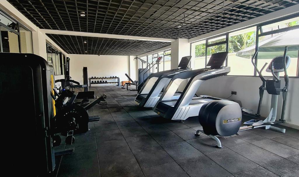 a gym with several treadmills and elliptical machines at Cozy Top-Floor Apartment with Balcony & City Views near United Nations Office in Ruaka