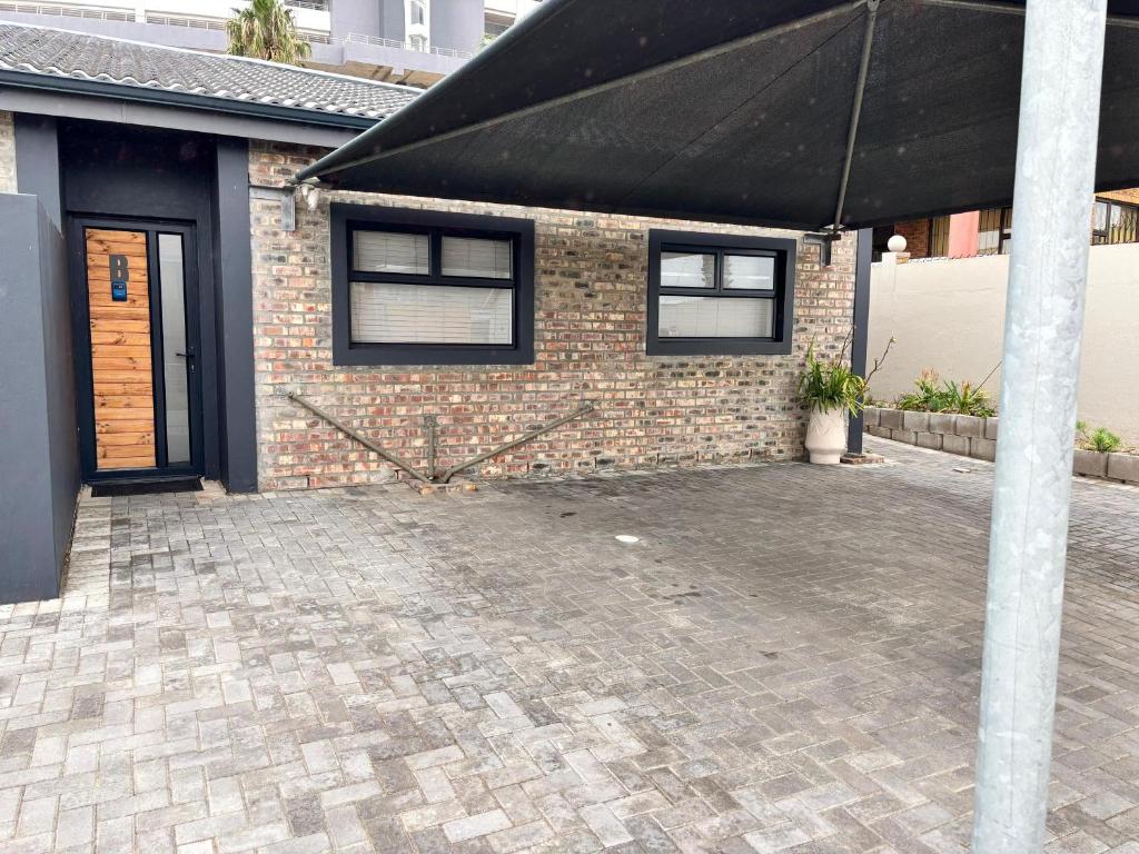 a brick house with a black umbrella in front of it at Bliss at Diaz in Mossel Bay
