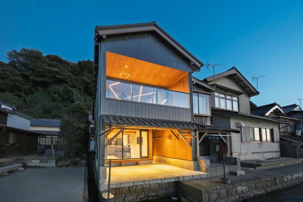 una casa con grandes ventanas al agua en 舟屋 栄-Funaya Sakasu-, en Kameshima