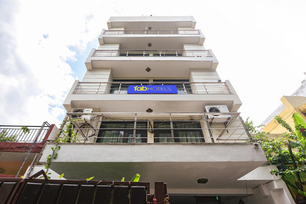 un edificio blanco alto con un letrero azul. en Via Chaudhary Palace, en Nueva Delhi